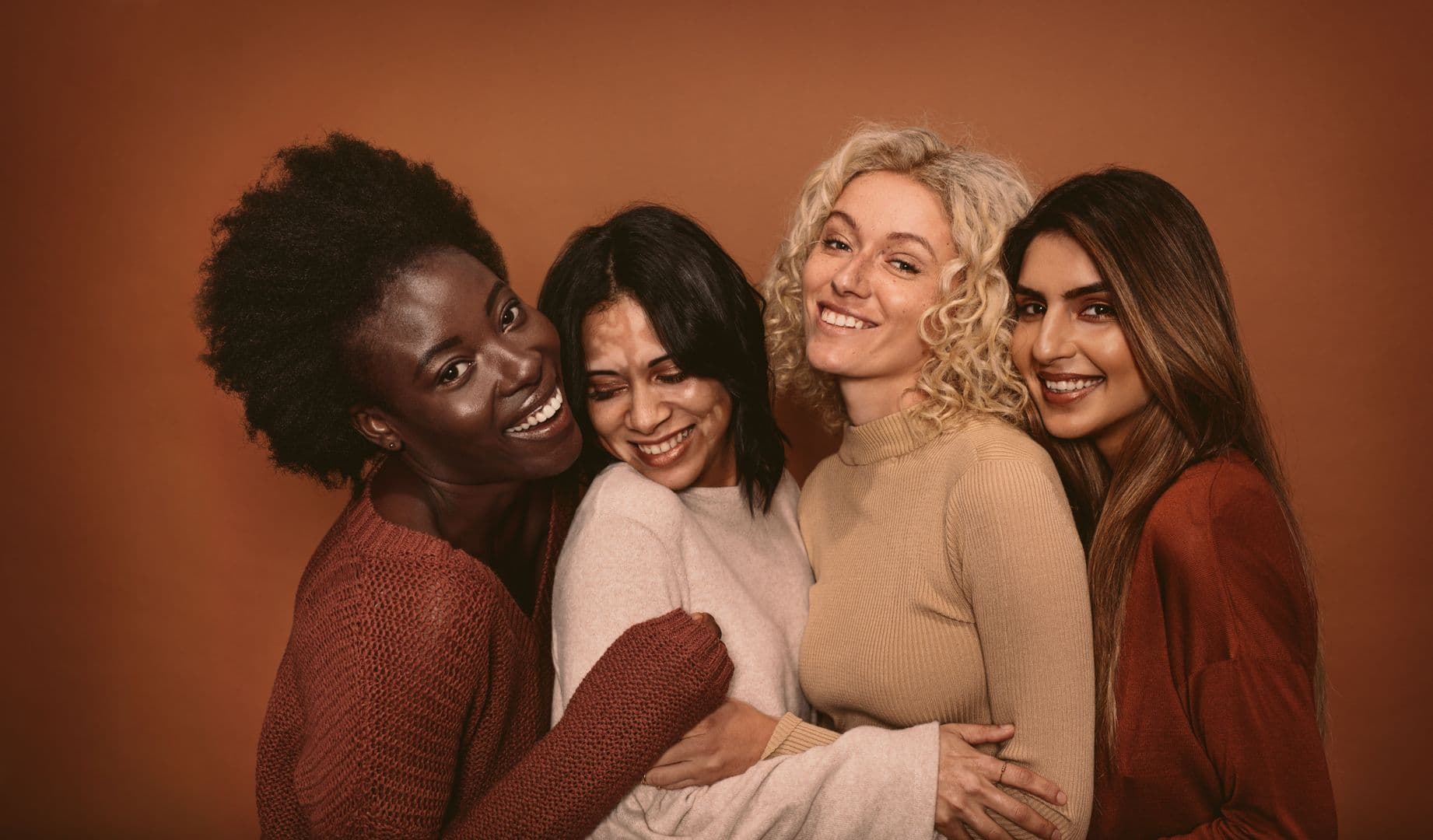 Women laughing and embracing each other